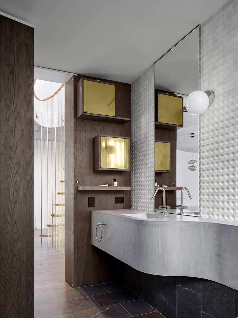 Изогнутая бетонная раковина и скамья интересную скульптурную деталь в этой современной дамской комнате. #ConcreteVanity #BathroomDesign