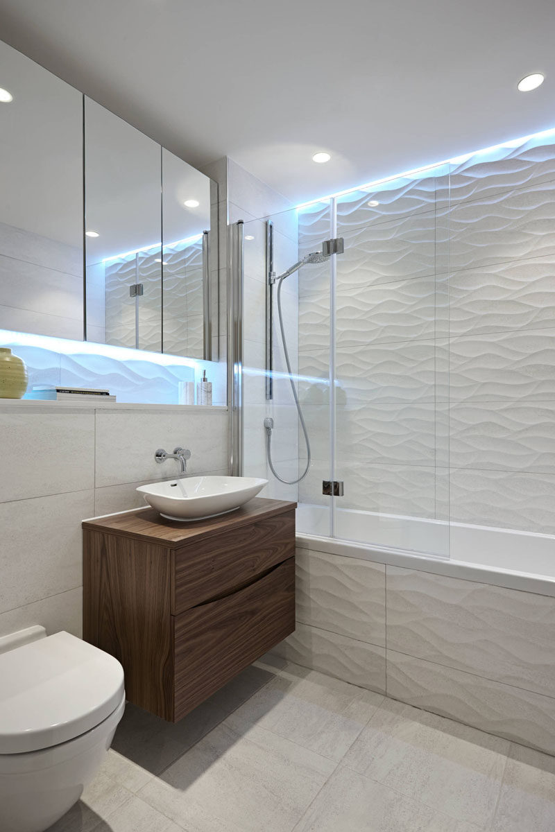 Идеи плитки для ванной - установите 3D-плитку, чтобы добавить текстуры в вашу ванную // Холодный свет над волнистой плиткой делает эту ванную комнату такой, будто она живет под водой.