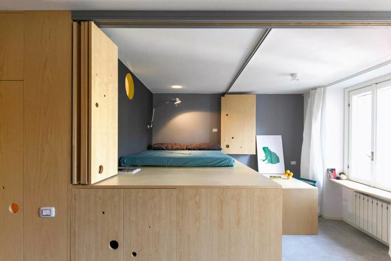 Эта деревянная стена открывается, открывая кровать-чердак, столовую и еще одно окно, добавляя больше света в квартиру 