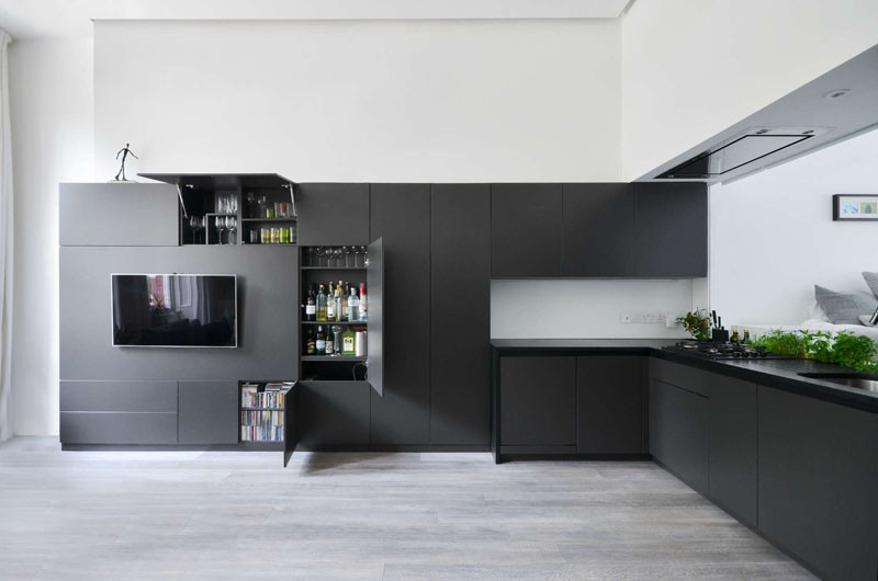 Черные кухонные шкафы опоясывают стену и становятся центром развлечений в этой лондонской квартире 