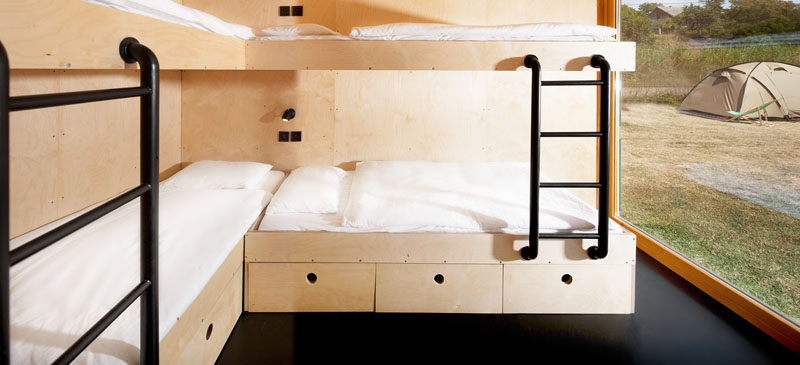 В этом бутик-отеле с морскими контейнерами есть комната с изготовленными на заказ двухъярусными кроватями из фанеры для четырех человек.