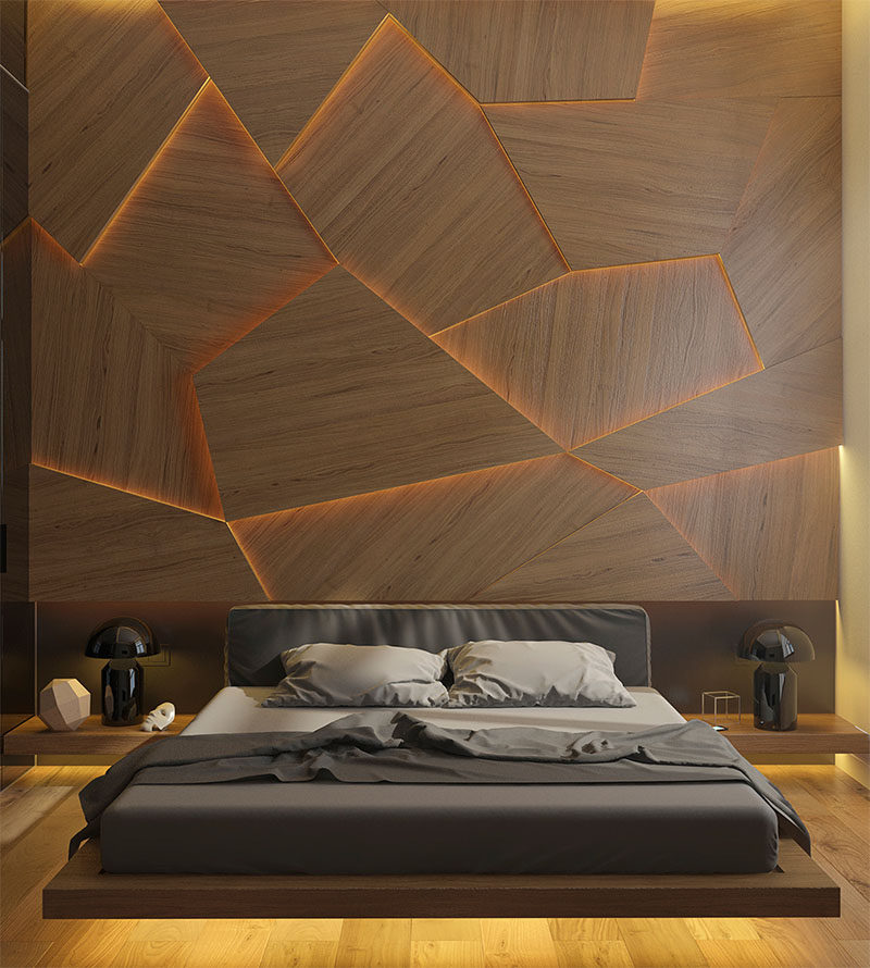 Акцентная стена спальни из деревянных панелей геометрической формы и скрытого светодиодного освещения.