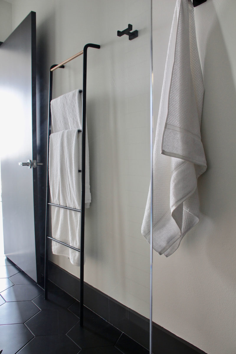 В этой современной ванной комнате черные крючки и вешалка для полотенец создают место, где можно повесить полотенца и одежду. # Дизайн для ванной # Крючки для ванной # Вешалка для полотенец