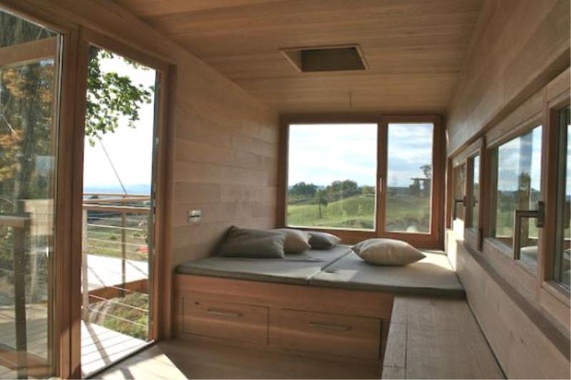 Интерьер деревянного домика на дереве с кроватью.