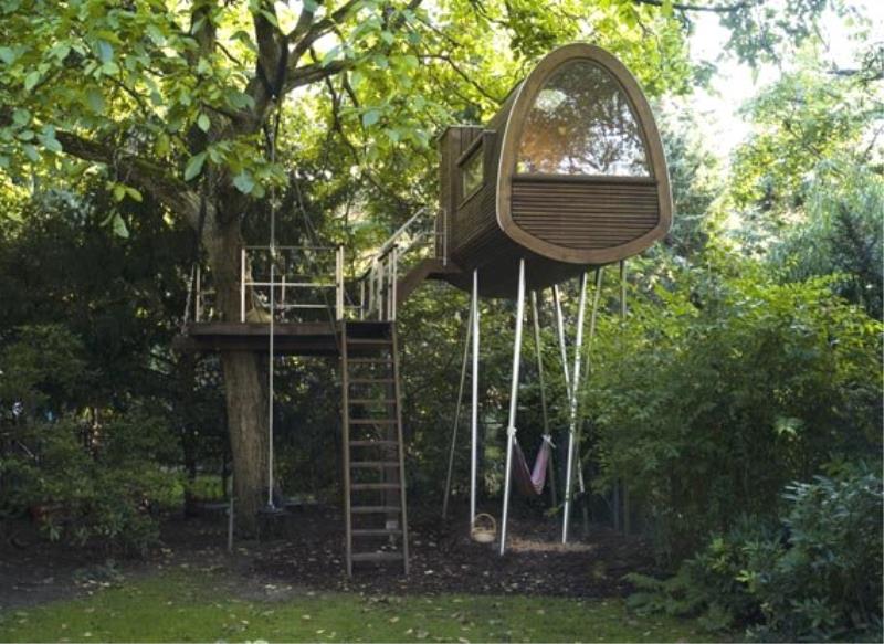 Современный изогнутый домик на дереве на металлических сваях.