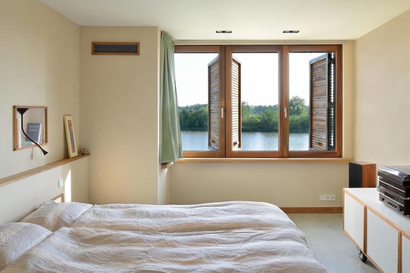 Нейтральная спальня с деревянными оконными ставнями.