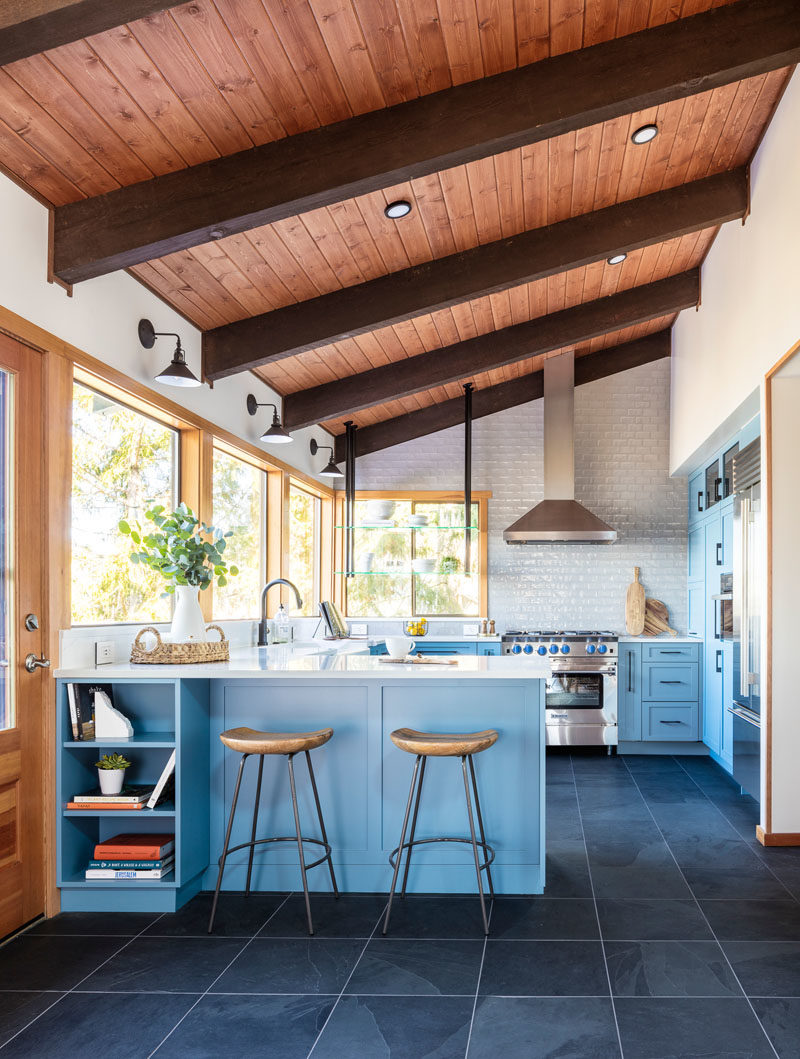 Идеи для кухни - Эта современная кухня отличается неожиданными синими шкафами, в которых сочетаются натуральные средние породы дерева, встречающиеся по всему дому, неровная светло-серая плитка на фартуке служит тонким, но ярким фоном для кухни, а пол из черного сланца и черные металлические акценты добавляют глубины и глубины. интерес. #KitchenIdeas #ModernKitchen #BlueKitchen #KitchenDesign