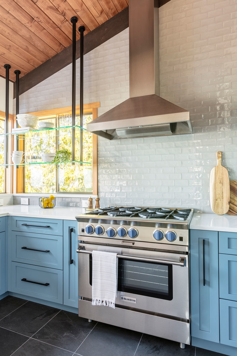 Идеи для кухни - По обе стороны от плиты есть выдвижные ящики для специй и посуды, благодаря которым все будет под рукой во время готовки, а специально разработанная система подвесных полок позволяет домовладельцам выставлять красивую посуду, сохраняя при этом вид. #KitchenIdeas #BlueKitchen #BlueCabinets #Stove #KitchenDesign