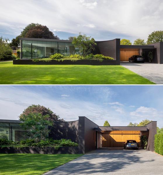 Фасад этого современного дома из черного кирпича имеет изгибы и большие встроенные вазоны, которые подчеркивают пышную зелень.