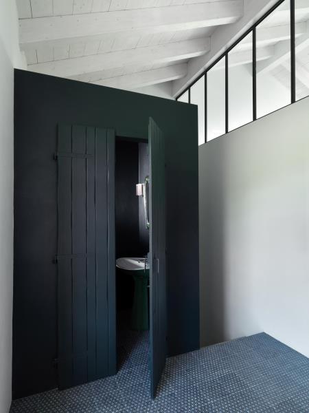 Туалетная комната с деревянными дверями, окрашенными в матовый черный цвет.