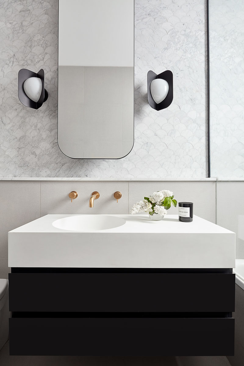 Идеи для ванных комнат - в этой современной ванной комнате круглое прямоугольное зеркало висит над небольшим черно-белым туалетным столиком, а черные бра дополняют нижнюю часть туалетного столика. #BathroomIdeas # ModernBathroom