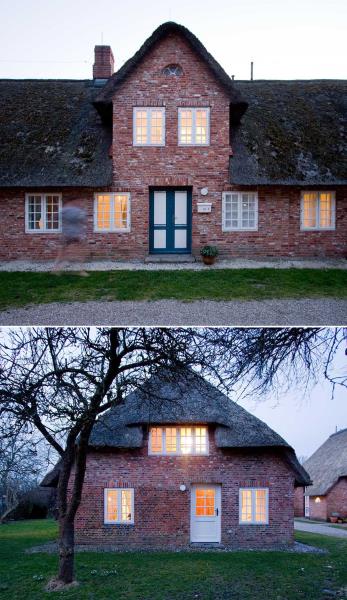 Кирпичный дом с соломенной крышей и белыми оконными рамами.