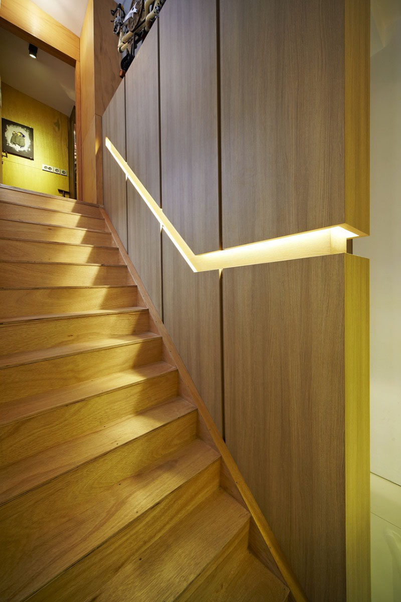 Идеи дизайна лестницы - 9 примеров встроенных перил // В этом сингапурском доме деревянная стена разделена встроенными перилами со скрытым освещением. #BuiltInHandrail #HandrailIdeas #HandrailDesign #StairDesign # Поручни