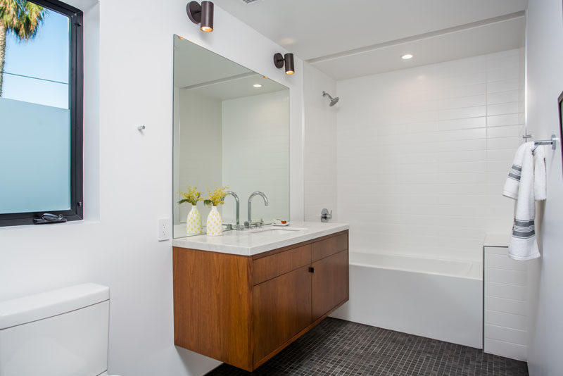 В этой ванной комнате есть частично матовое окно для уединения, совмещенный душ и ванна, а также плавающий туалетный столик.