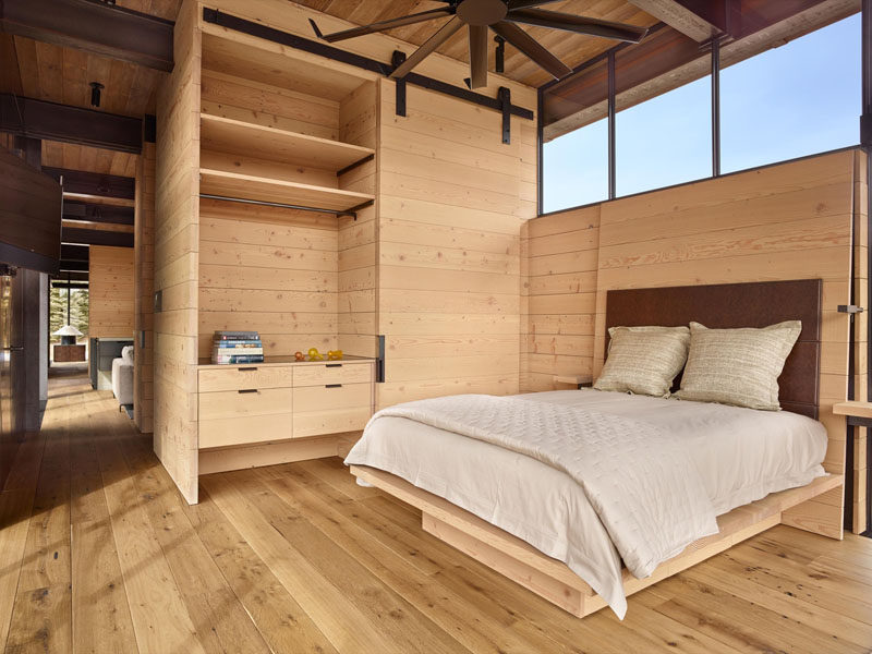 Эта спальня создает теплую и уютную атмосферу с использованием дерева, однако в нее также включены такие промышленные элементы, как вентилятор и раздвижная дверь сарая.