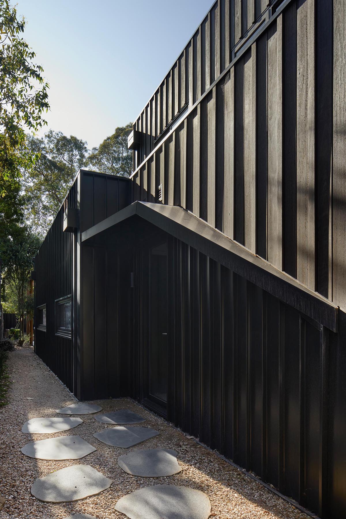 Внешний вид этого современного дома демонстрирует деревянную облицовку Blackbutt, подчеркнутую черными металлическими оконными рамами.