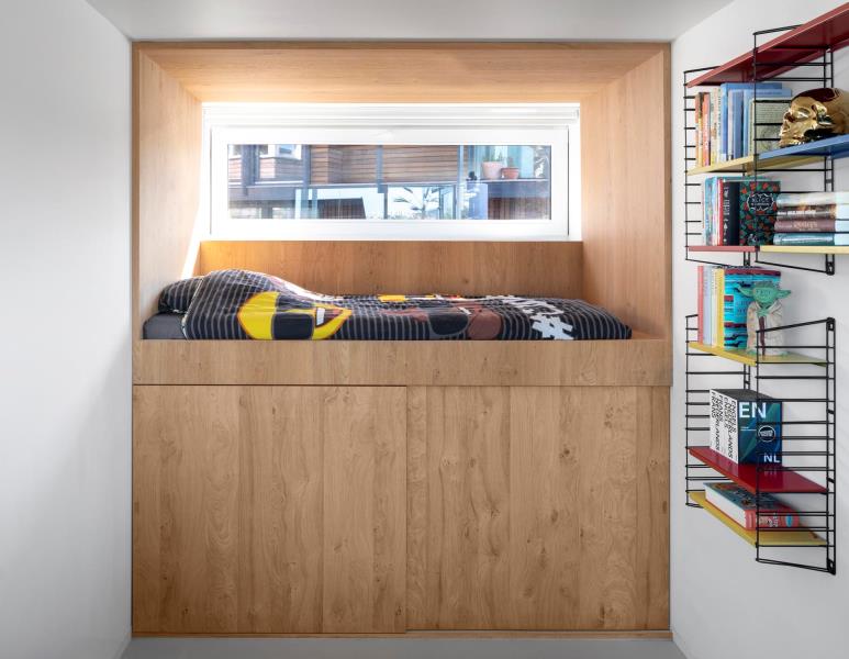 Спальни этого современного плавучего дома расположены на нижнем уровне и оснащены кроватями-чердаками, изготовленными по индивидуальному заказу, с деревянной отделкой.