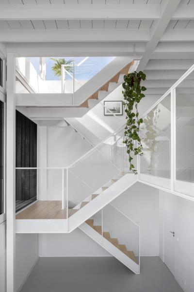 Белая лестница в этом современном плавучем доме сочетается со стенами и потолком, соединяет различные уровни плавучего дома и добавляет в пространство теплый деревянный элемент.