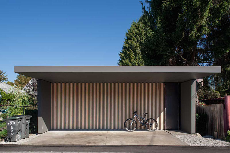 18 вдохновляющих примеров современных гаражных ворот // Тонкие вертикальные панели из светлого дерева на этих гаражных воротах создают современный образ и уникальность.