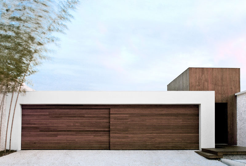 18 вдохновляющих примеров современных гаражных ворот // Раздвижная деревянная дверь, сделанная из того же дерева, что и снаружи, помогает двери гармонировать с интерьером.