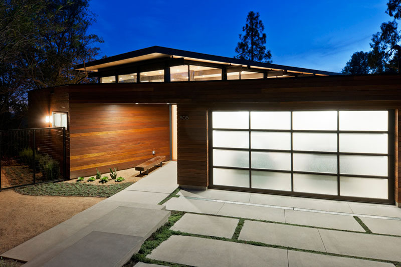 18 вдохновляющих примеров современных гаражных ворот // Панели из матового стекла обеспечивают уединение и придают яркость экстерьеру при освещении изнутри.