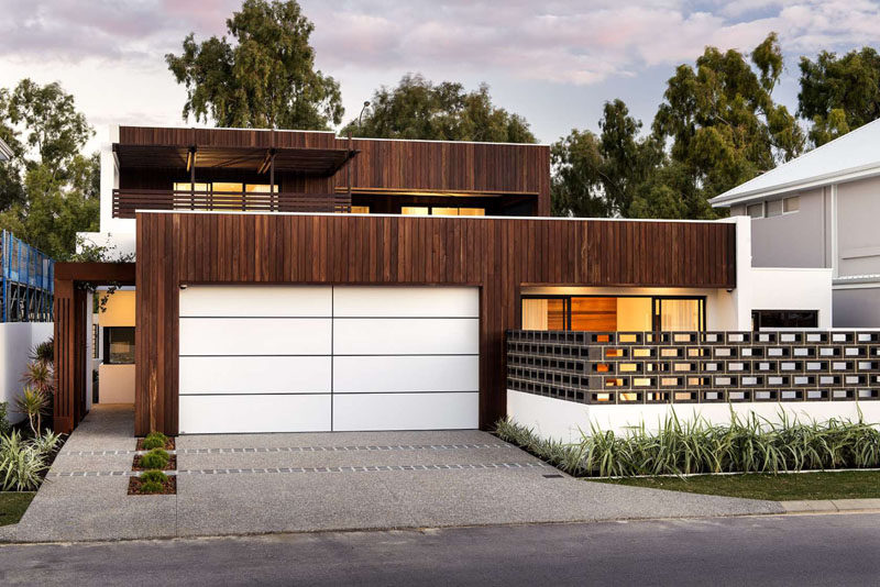 18 вдохновляющих примеров современных гаражных ворот // Ярко-белые гаражные ворота с темными линиями неожиданно и современно контрастируют с деревянным фасадом.