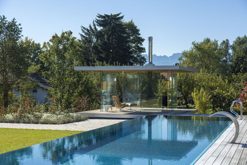 Этот современный стеклянный дом у бассейна имеет панорамный вид, раздвижные двери со всех сторон, подвесной камин и скрытый холодильник в полу. 
