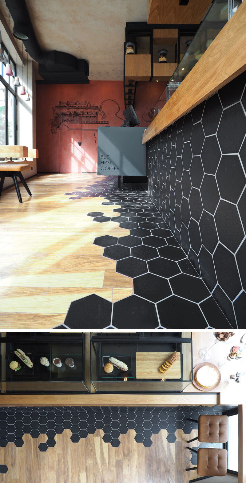 Черная шестиугольная плитка и деревянный ламинат - элемент дизайна в этом современном кафе.