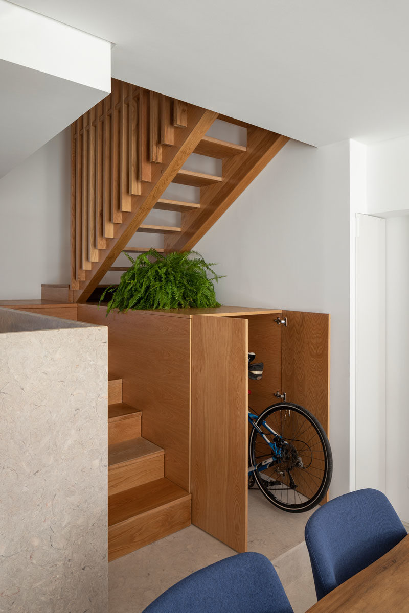 Идеи для хранения вещей - в этом небольшом доме есть шкаф под лестницей, который проходит в глубину лестницы. Шкаф достаточно велик, чтобы спрятать велосипед, и предоставляет место для демонстрации декоративных предметов и растений. #HiddenStorage #UnderStairStorage #BikeStorage #InteriorDesign #StairDesign #StorageIdeas