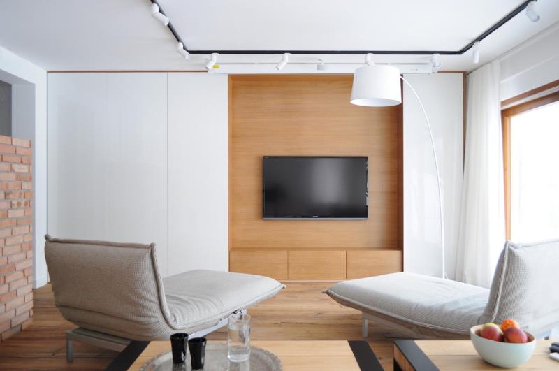 Сдвижные белые настенные панели открываются, чтобы открыть скрытый телевизор.