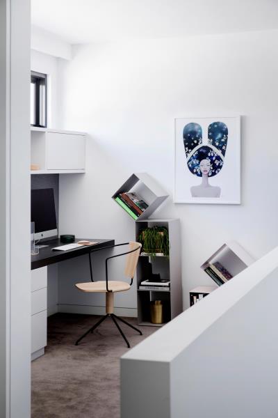 Уголок домашнего офиса с индивидуальным столом и шкафами, а также отдельно стоящими книжными полками.