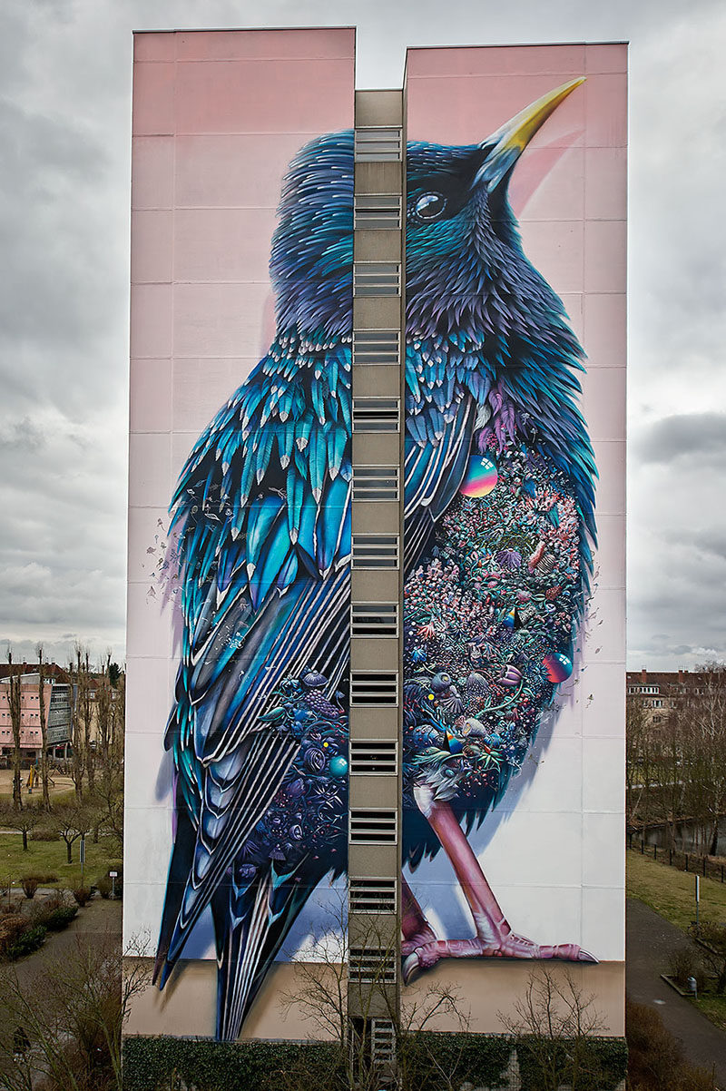 Это большое красочное панно с изображением птицы можно найти на здании здания в Германии 