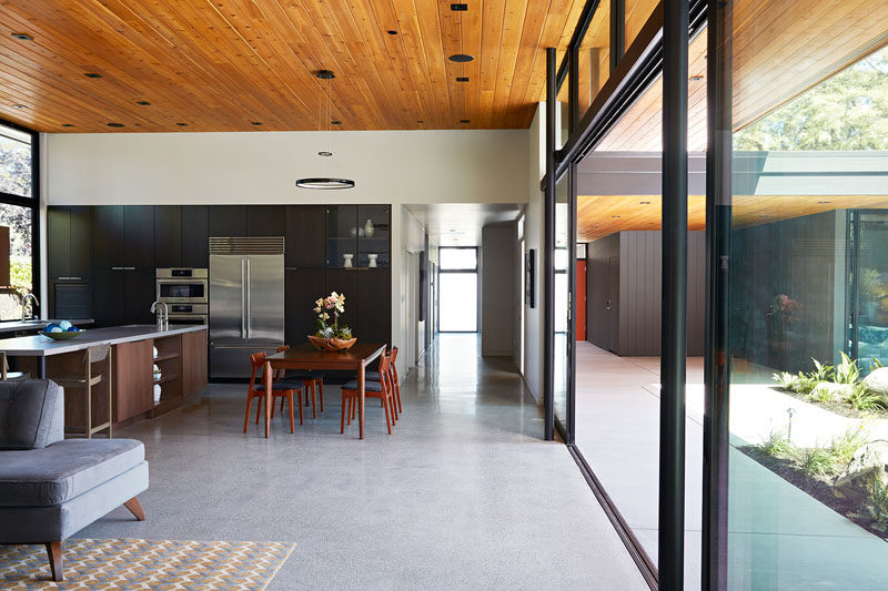 Большая стеклянная стена может быть открыта, чтобы сделать основную жилую зону в этом доме идеальной для жизни в помещении / на открытом воздухе 