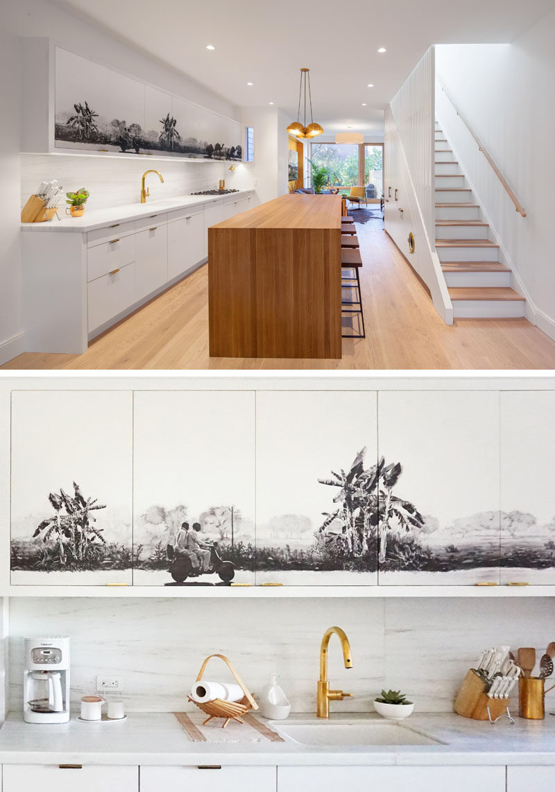 Идеи для кухни - черно-серая фреска была добавлена ​​к верхним шкафам этой современной кухни из белого и дерева, создавая центральный фокус для интерьера открытой планировки. #KitchenIdeas #KitchenCabinets # Mural # Art #KitchenDesign # ModernKitchen