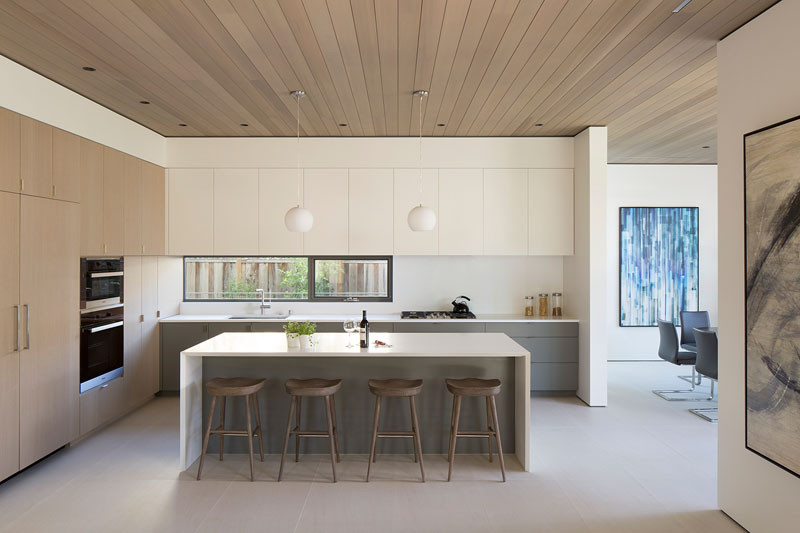 Эта современная кухня соединена с гостиной и столовой парящим потолком из кедра. #KitchenDesign #WoodCeiling