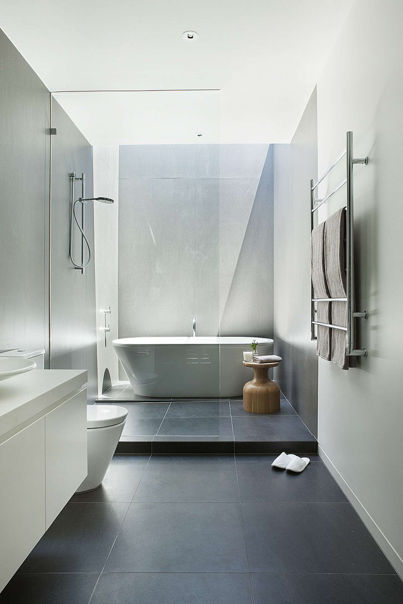 Идеи плитки для ванной комнаты - используйте большую плитку на полу и стенах // Большая темная напольная плитка в сочетании со светлыми стенами в этой ванной комнате делает комнату больше и более открытой.