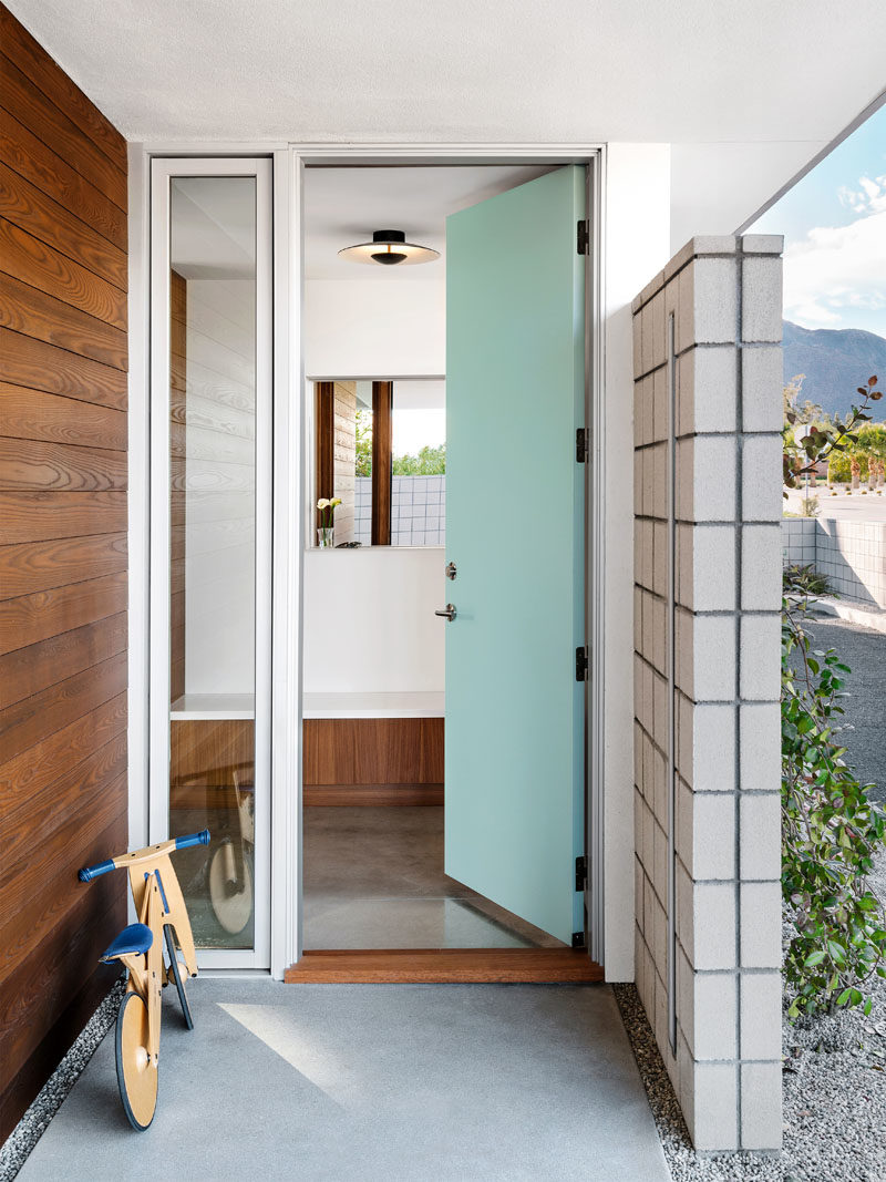 Идеи входной двери - Голубая входная дверь приветствует посетителей этого современного дома середины века с полированным бетонным полом. #BlueFrontDoor #FrontDoorIdeas #MidCenturyModern