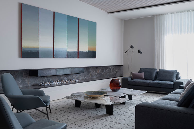 Идеи для гостиной. В этой современной гостиной шесть панелей пейзажа Филипа Вольфхагена «Третье предложение: Триптих» простираются над очень широкой каминной полкой. # Жилая комната # Камин # Жилая комнатаИдеи
