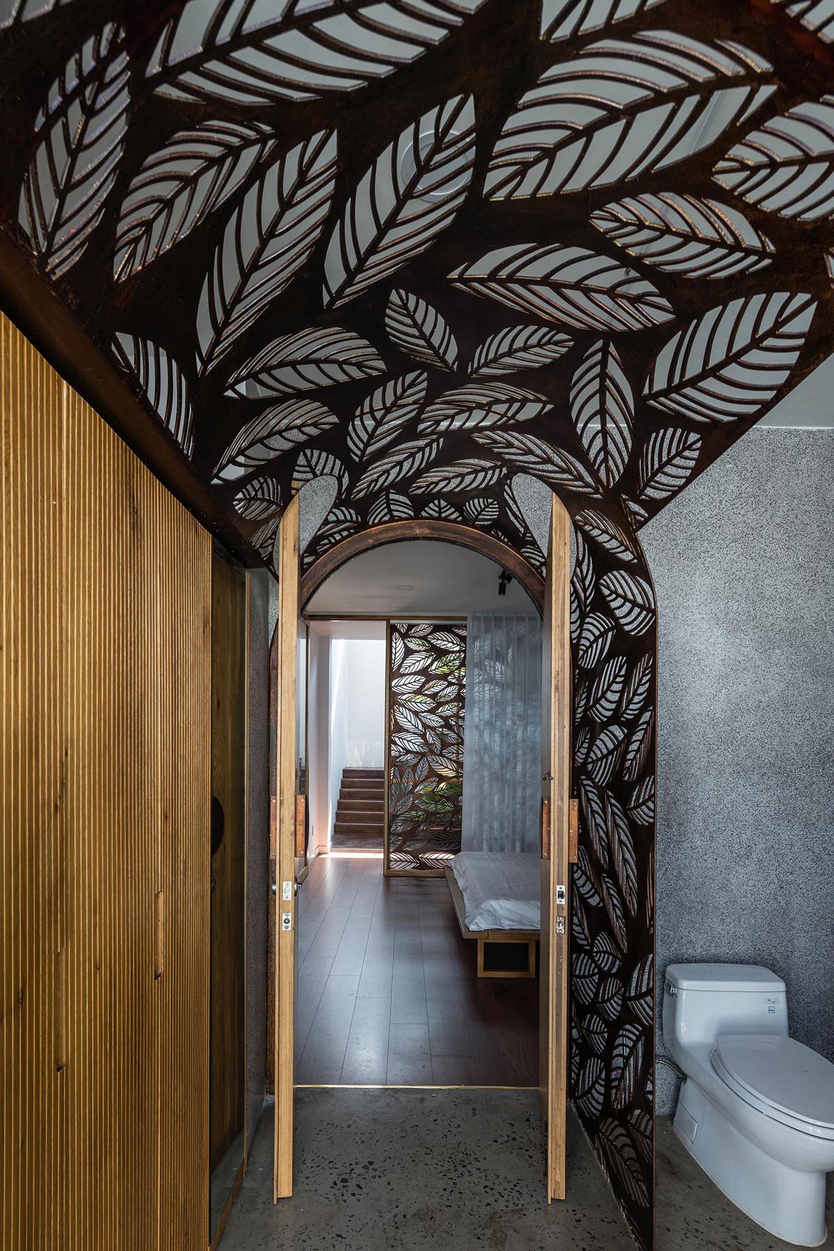 В этих современных ванных комнатах декоративная металлическая ширма с мотивом листьев использовалась в качестве фона для тщеславия и как способ выделить дверной проем.