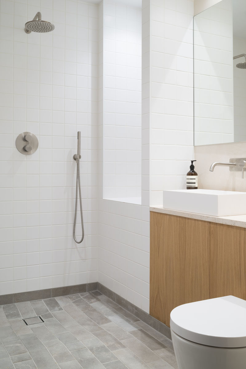 В этой минималистская ванная комната простая белая квадратная плитка покрывает стены, небольшая серая плитка из известняка покрывает пол. # СовременнаяВанная 