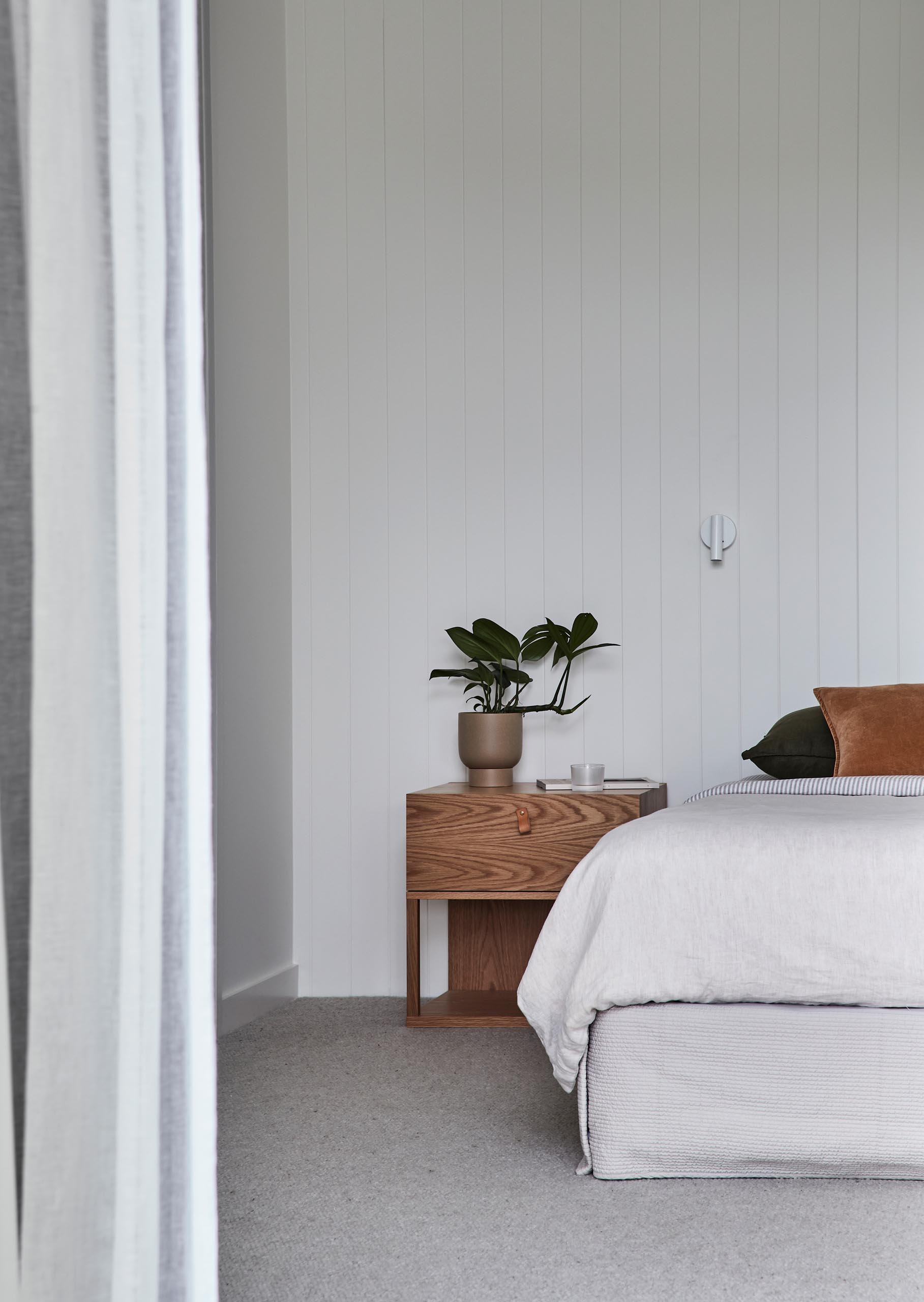 В этой современной спальне сохранен минималистичный дизайн, а акценты из дерева и кожи напоминают другие части дома.