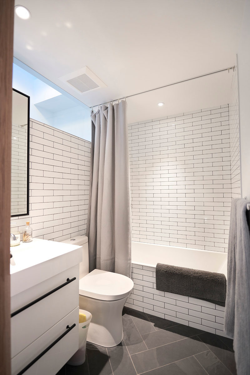 Идеи дизайна ванной комнаты - в этой современной ванной комнате стены выложены белой плиткой в ​​стиле метро, ​​а занавеска для душа свисает с направляющей в потолке. #BathroomIdeas #BathroomDesignIdeas #ShowerCurtain