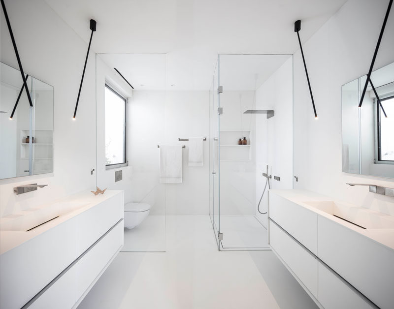  Эта современная главная ванная комната ярко-белого цвета, минималистичным черным освещением и стеклянной перегородкой для душа от пола до потолка. # Современная # БелаяВанная 