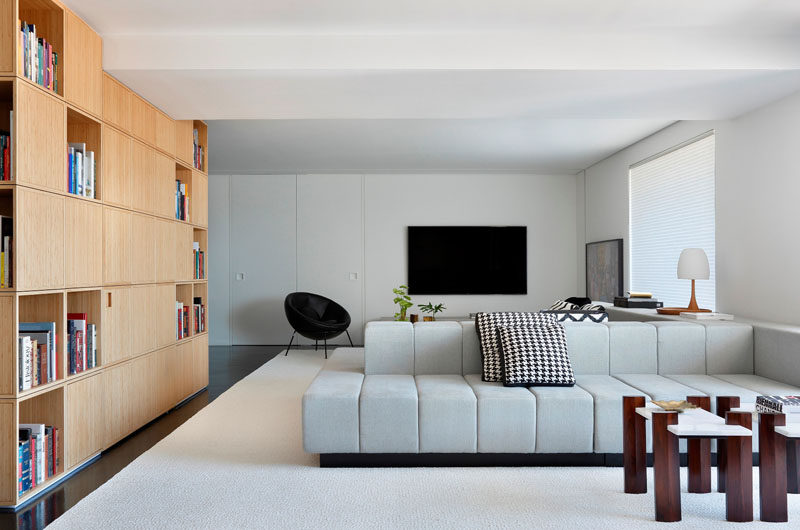 Жилая площадь этой современной квартиры разделена на две части двухсторонним диваном по центру.