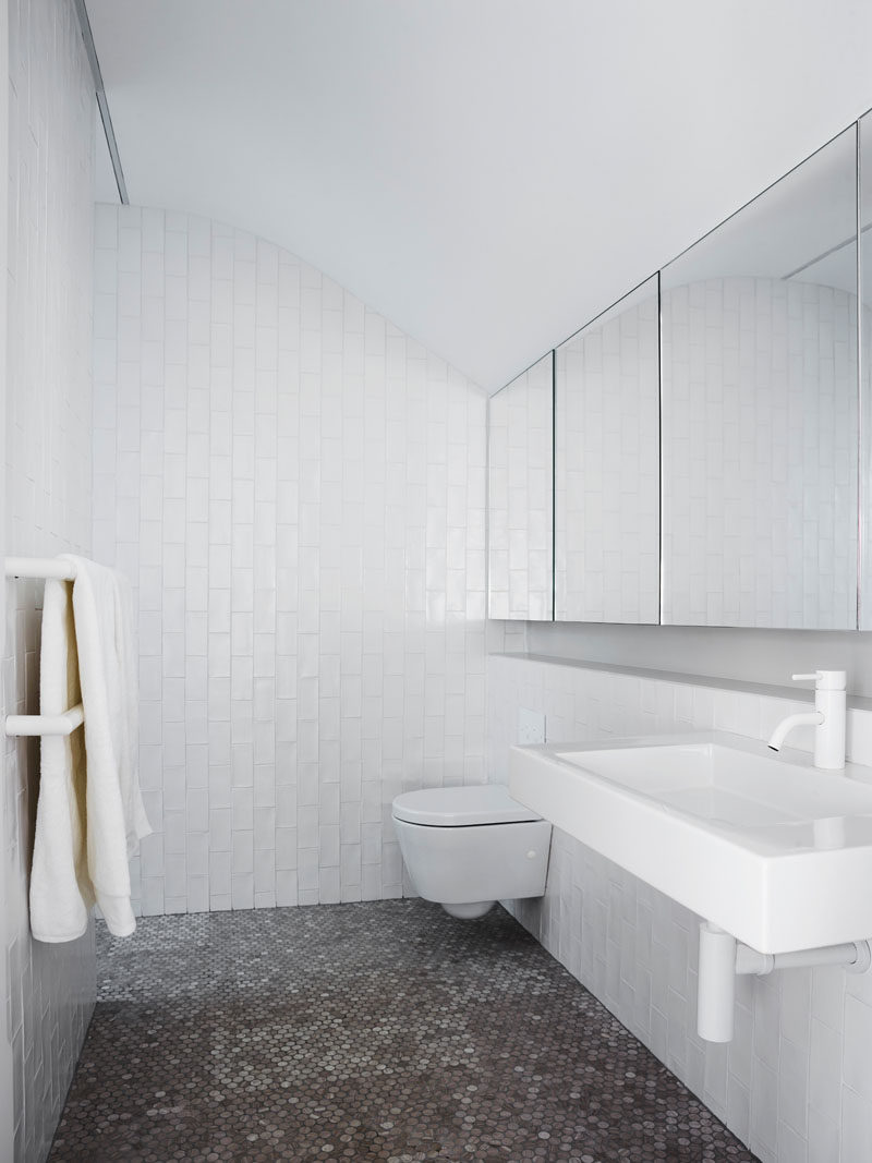 В ванной комнате пенни-плитка покрывает пол, а белая плитка метро, ​​уложенная вертикально, покрывает стены, а зеркала отражают свет и изгибаются на потолке. # Современная ванная # Дизайн ванной 