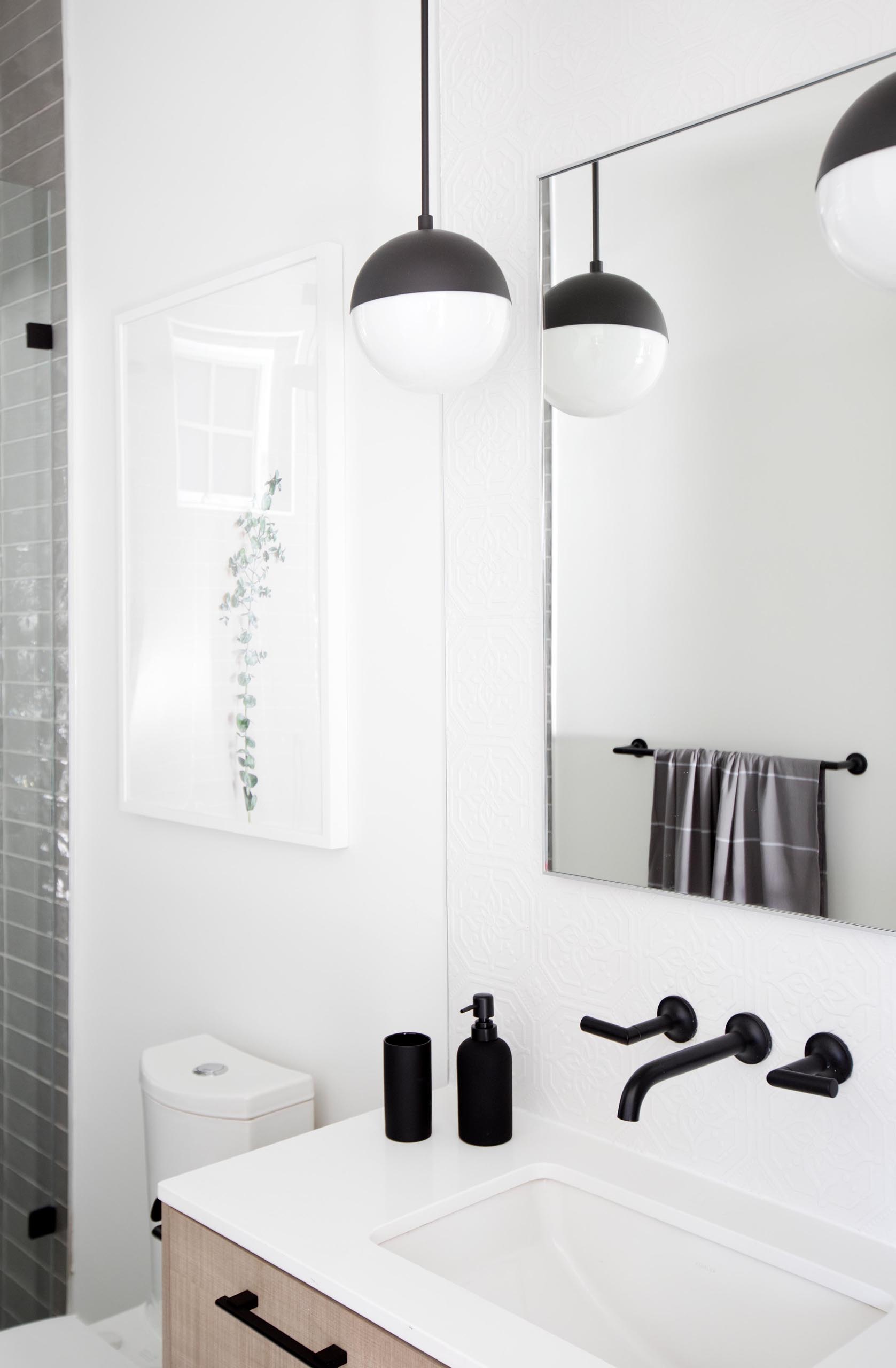 Современная ванная комната с деревянным туалетным столиком с белой столешницей и душем, облицованным серой плиткой от пола до потолка.