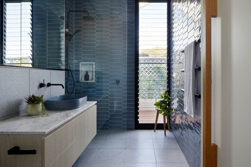 Идеи для ванных комнат - в этой современной ванной комнате синяя плитка была использована для добавления цвета пространству, а в душе встроенная полка дополняет плавающую столешницу под туалетный столик. #BlueBathroom #BathroomIdeas # TileIdeas