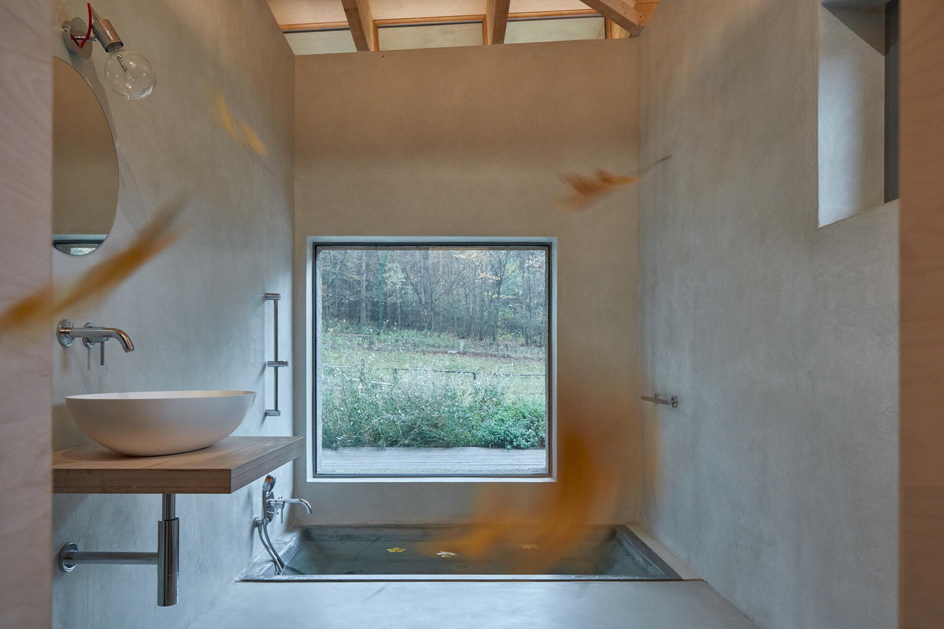 Эта современная ванная комната в каюте была разработана с встроенной ванной на уровне пола, минималистичным деревянным туалетным столиком и большим панорамным окном.
