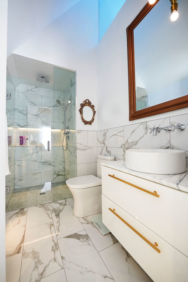 Идеи для ванных комнат - В этой современной главной ванной комнате потолочное окно добавляет естественный свет в пространство, а душевая кабина имеет встроенную полку и закрыта стеклянной дверью. #BathroomIdeas # ModernBathroom