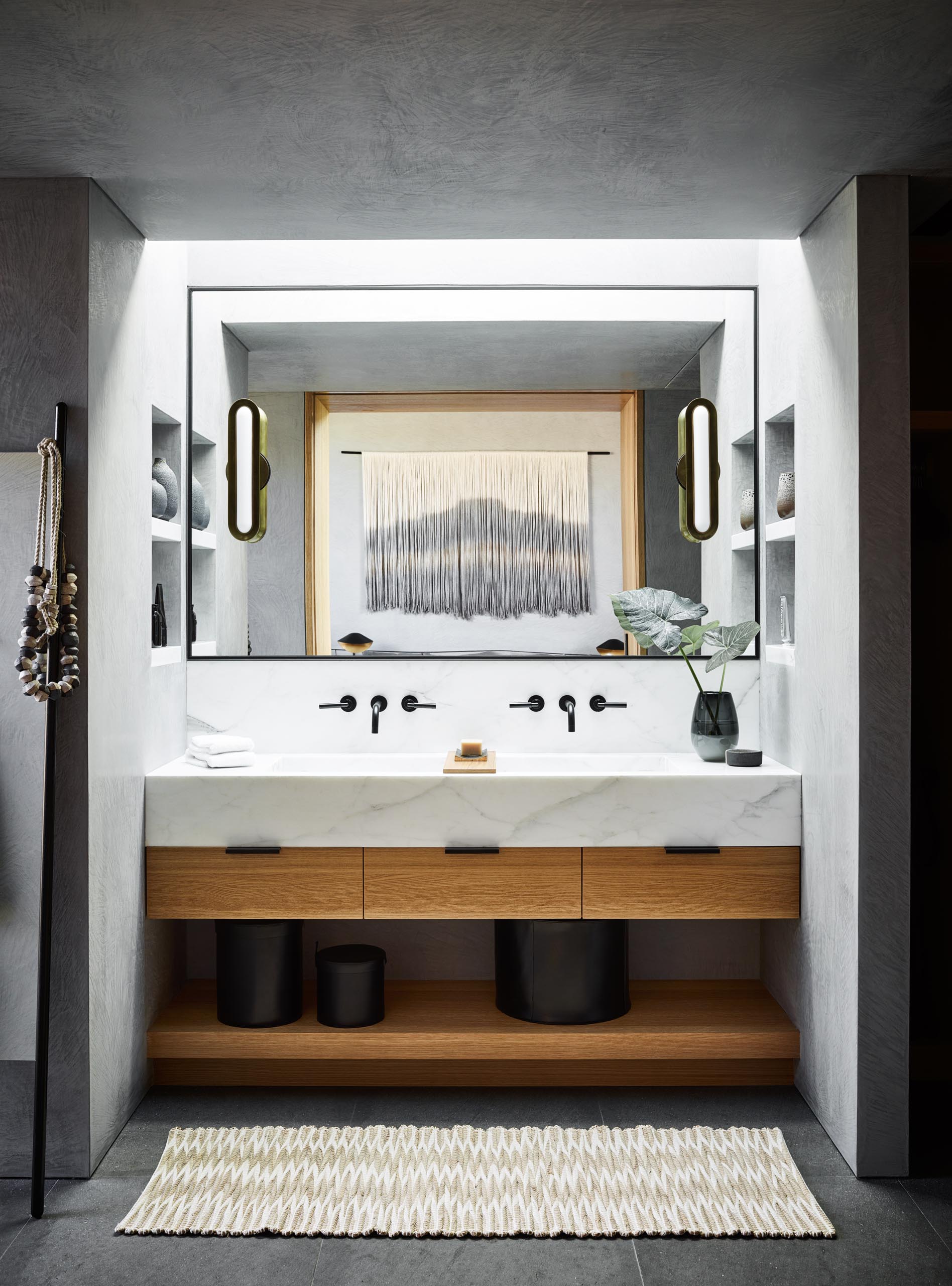 В этой современной ванной комнате потолочное окно освещает туалетный столик, а ниши для стеллажей расположены с обеих сторон.